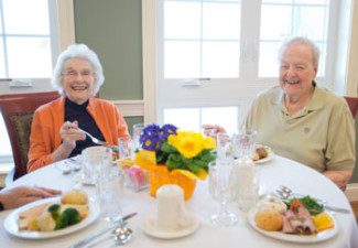 image of assisted living residents enjoying a meal together