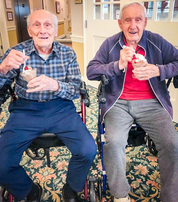 happy men in assisted living enjoying ice cream